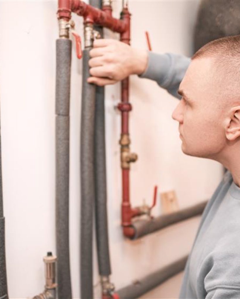 man-fixing-water-heating-pipe-boiler-room